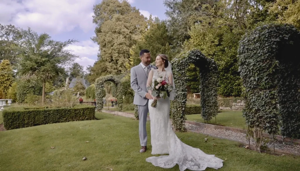 Bride and groom among clipped hedges and ivy arches in a formal garden