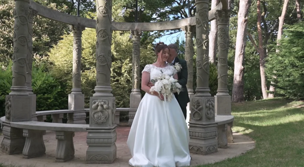 Bride and groom in the carved stone pergola at Rushpool Hall