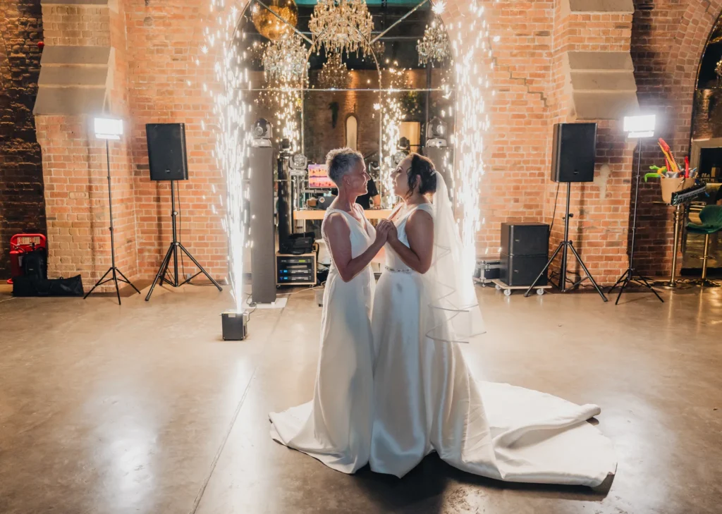 Two brides share their first dance between sparkler fountains