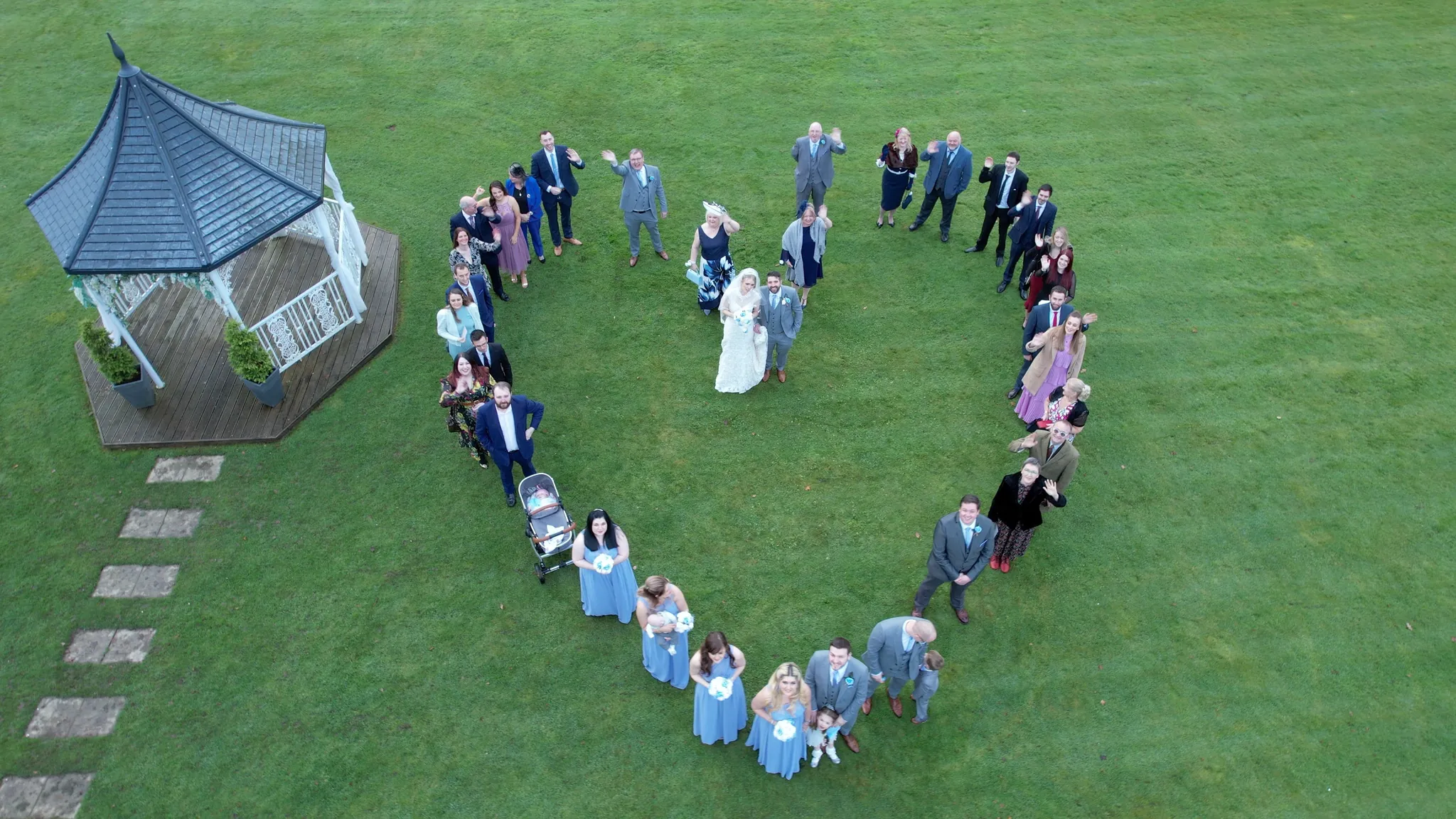 Wedding guests forming a heart on the lawn, seen from a drone