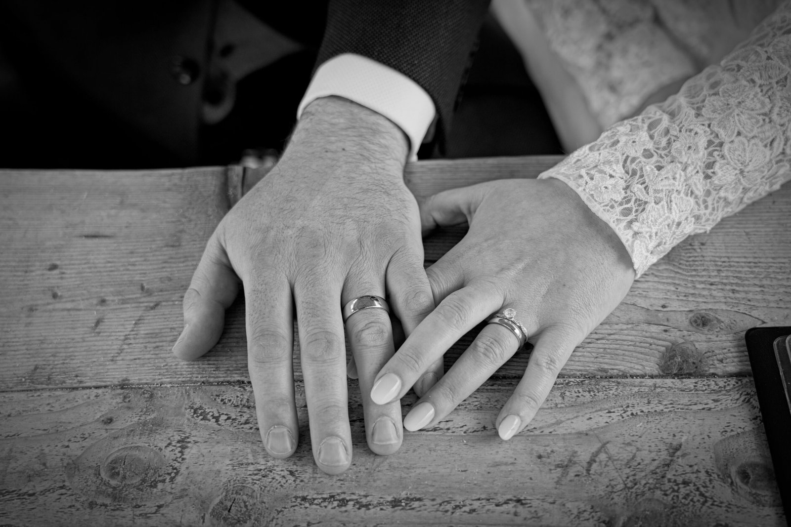 The couple’s hands and wedding rings, in black and white