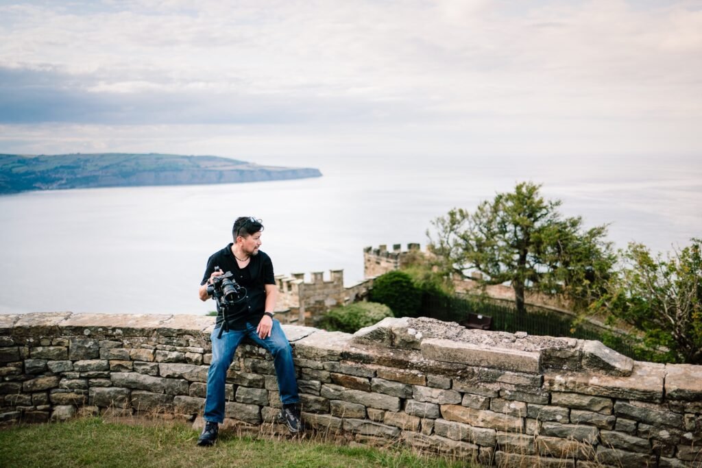 Filming on a clifftop wall above the sea