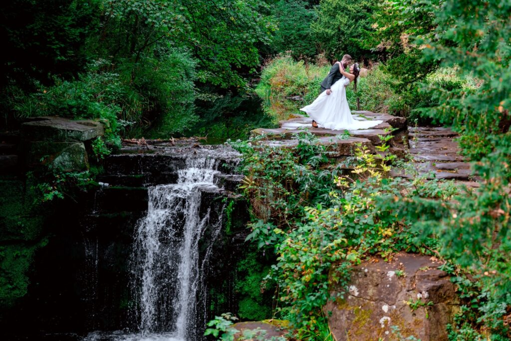 A wedding couple kisses on Jesmond Dene Waterfall